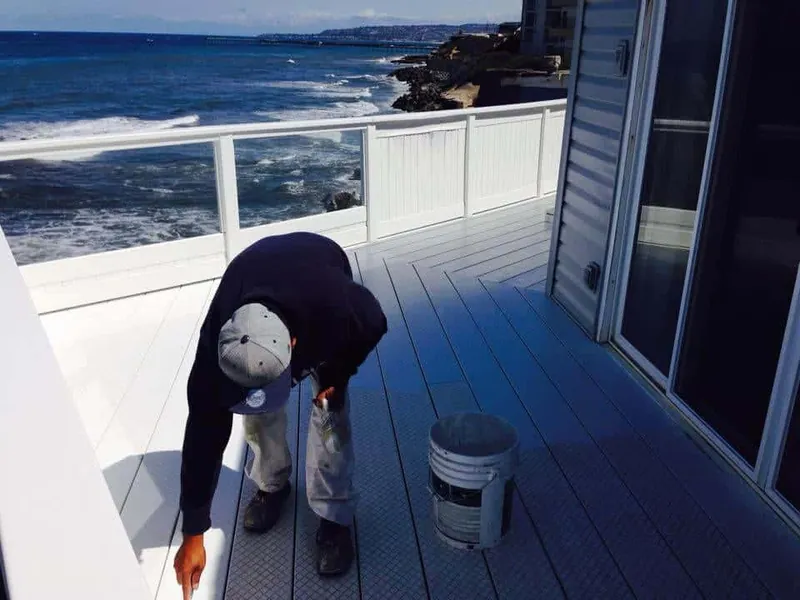 Painter painting an oceanfront deck