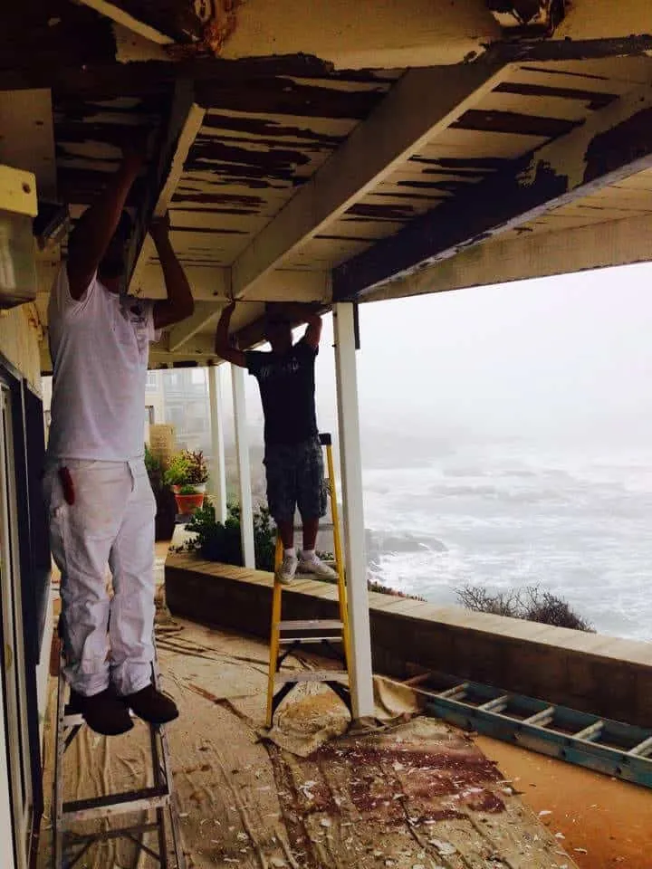 Crew prepping the underside of an oceanfront deck
