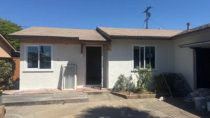 Front of the house with fresh white stucco and new windows