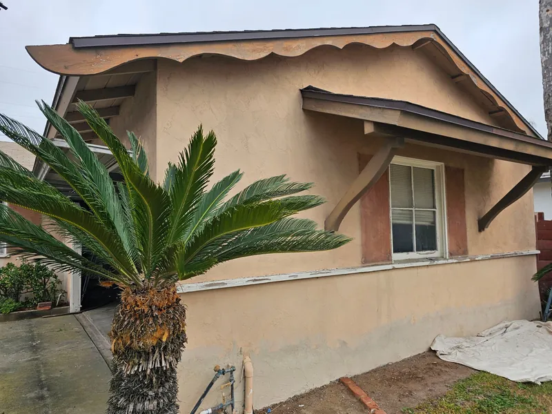 Front gable mid-project with stucco patches and trim in progress
