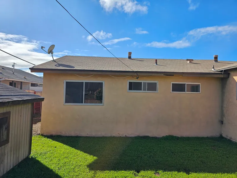 Back of a Clairemont ranch home with faded tan stucco before painting
