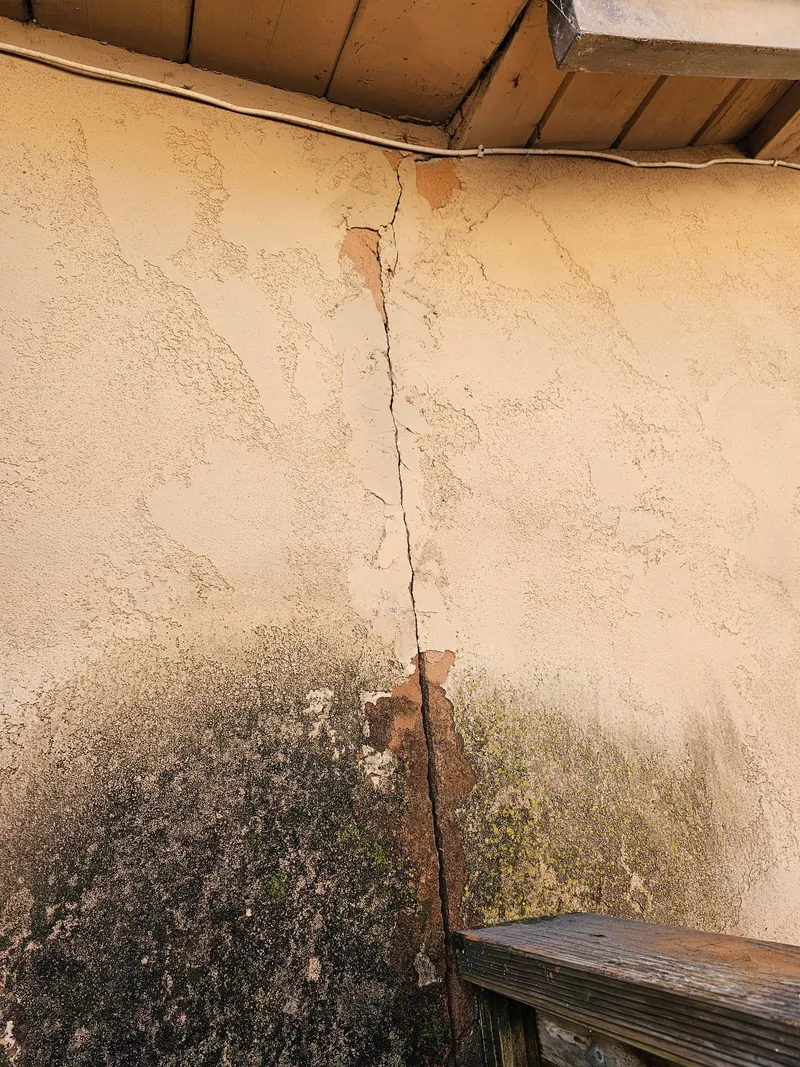 Vertical stucco crack and staining at an inside corner
