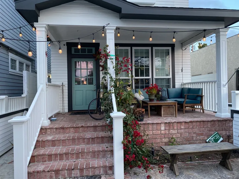 Front porch with white railings and a teal door after painting