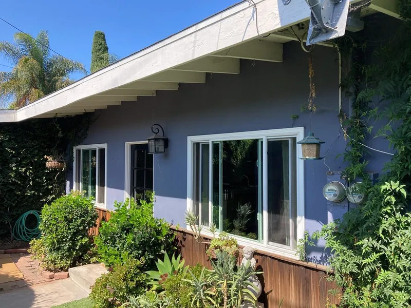 Navy blue stucco home with white trim and garden in Coronado