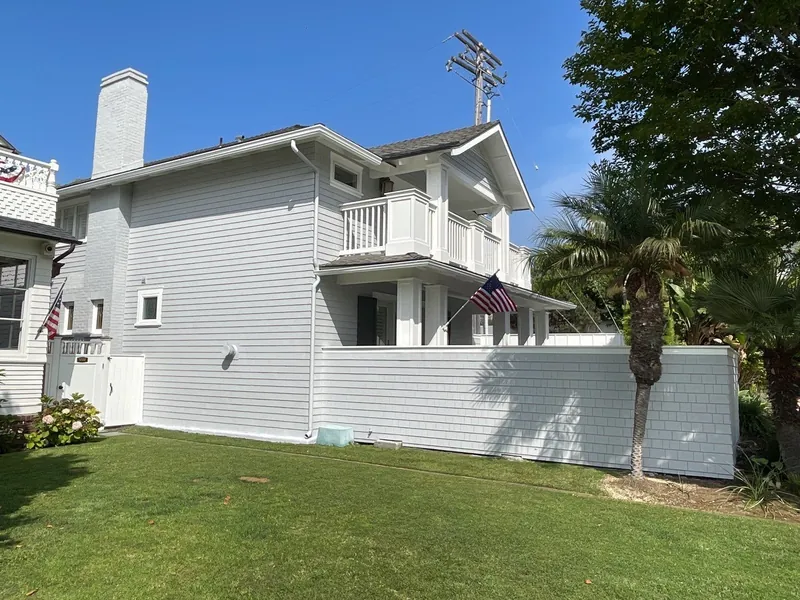 White two-story home and fence after a full exterior renovation
