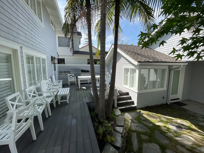 Rebuilt deck and patio beside a white cottage