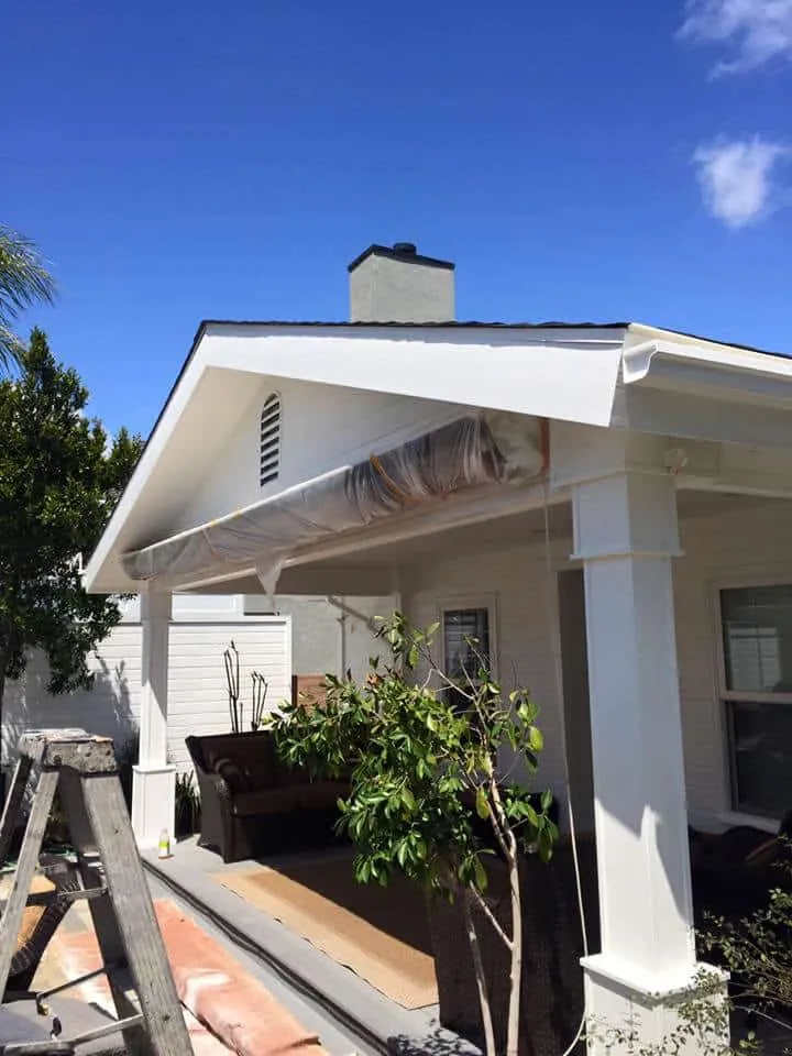 New gutter and painted porch columns on a white craftsman
