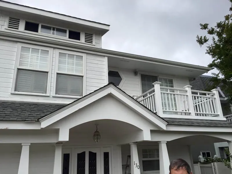 White front porch, gable and balcony railing after painting