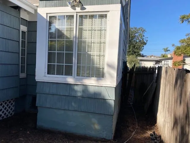 Bay window and blue siding before repainting