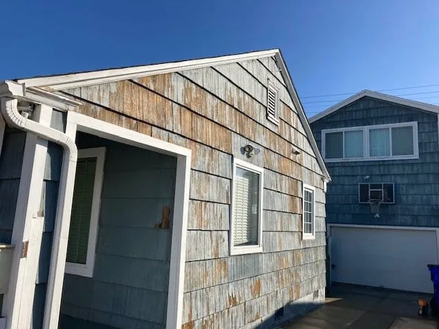 Weathered shingle siding and trim before restoration