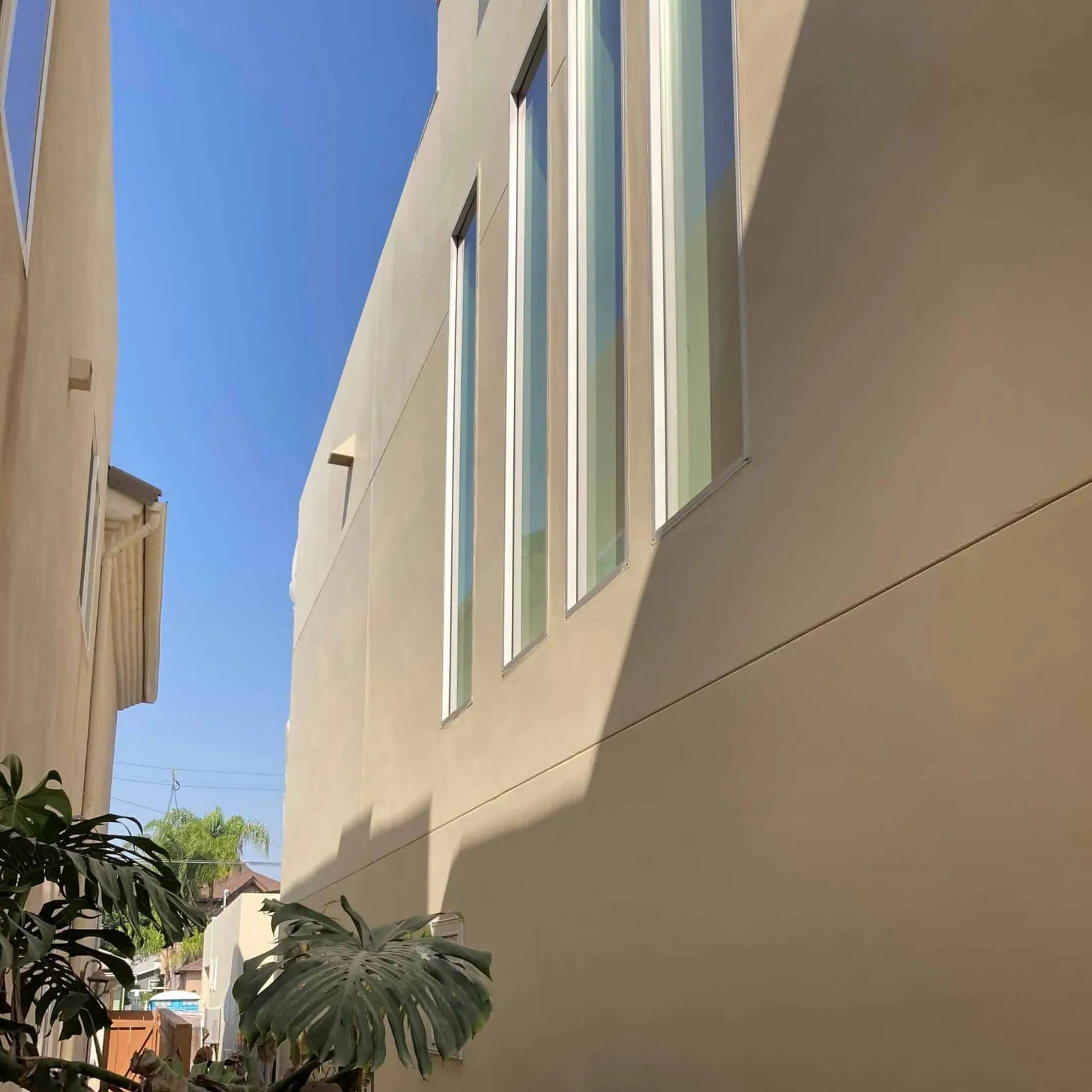Side of a modern Coronado home with freshly painted smooth stucco