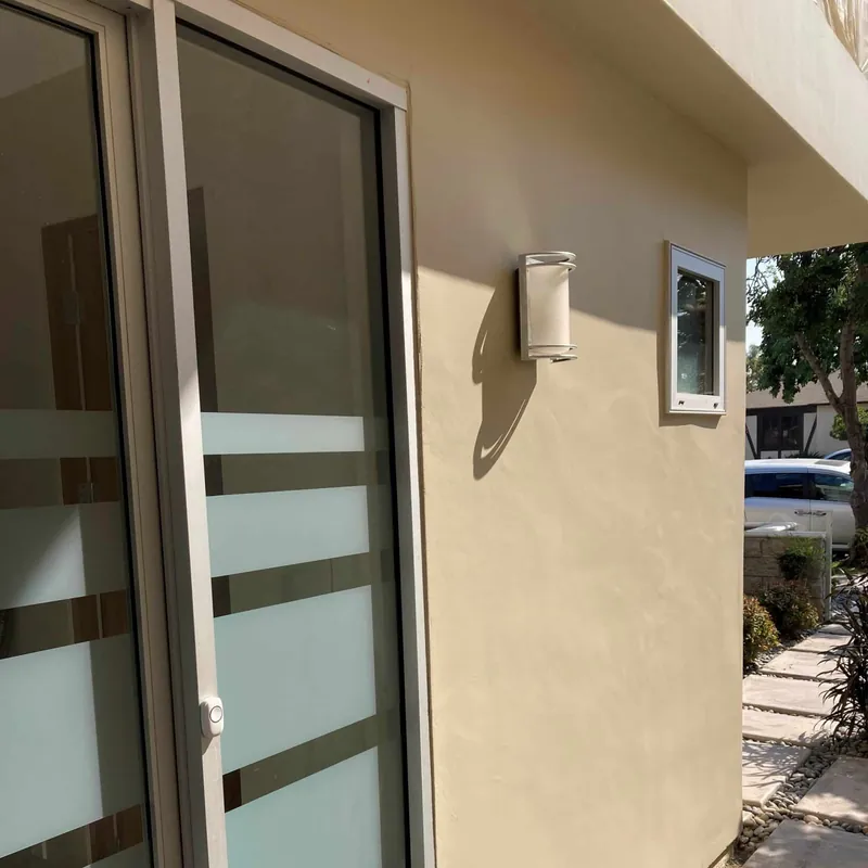 Painted smooth stucco around a sliding door and wall light
