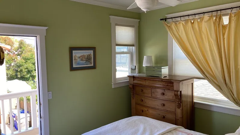 Bedroom painted sage green with crisp white trim