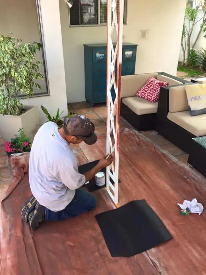 Painter hand-brushing a decorative metal column