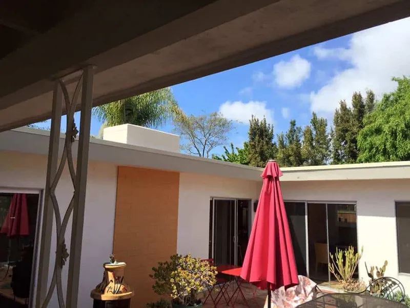 Covered patio with painted beams and iron columns