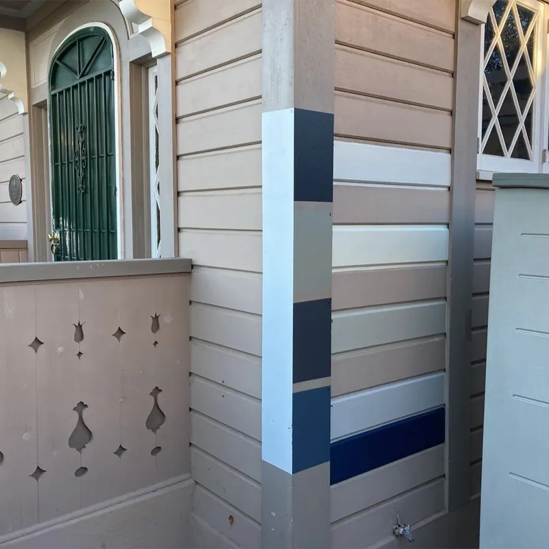 Paint color samples brushed onto siding for the homeowner to compare