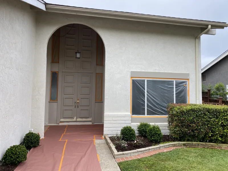 Front entry and windows masked off for exterior spraying