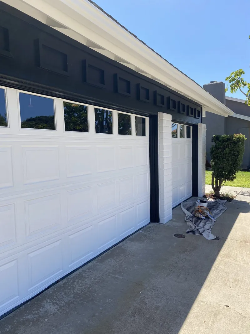 White garage doors with crisp black trim after painting