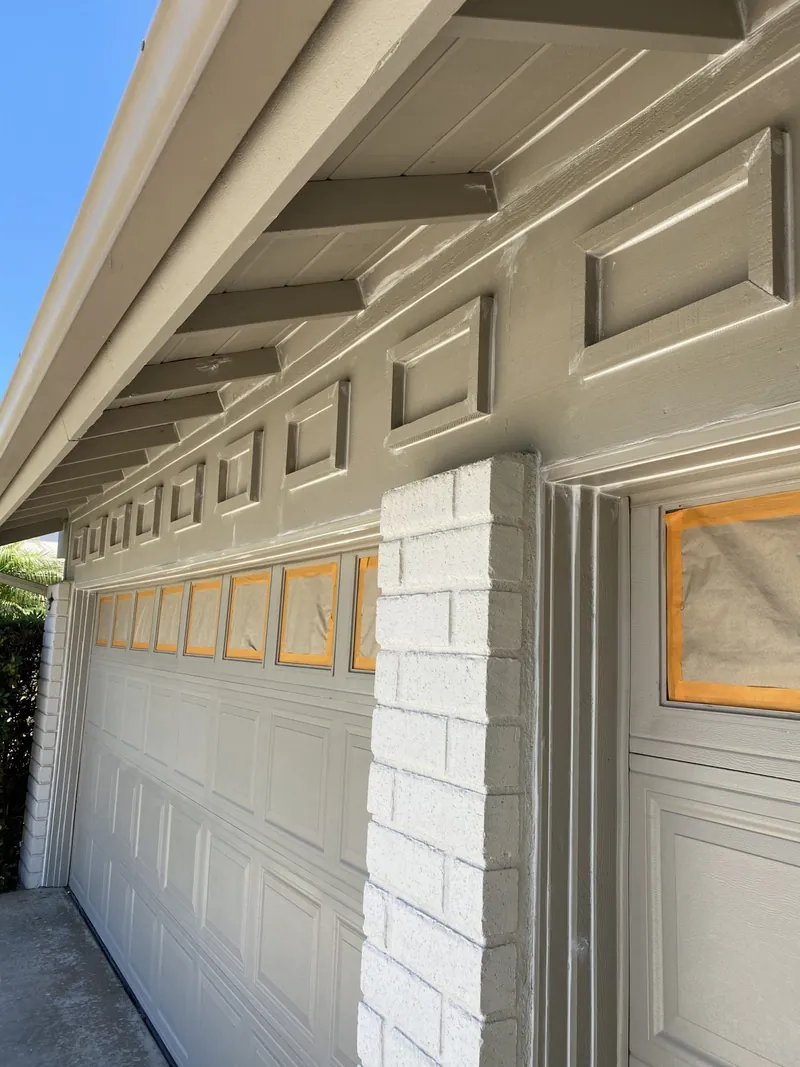 Garage trim and windows masked during exterior painting prep