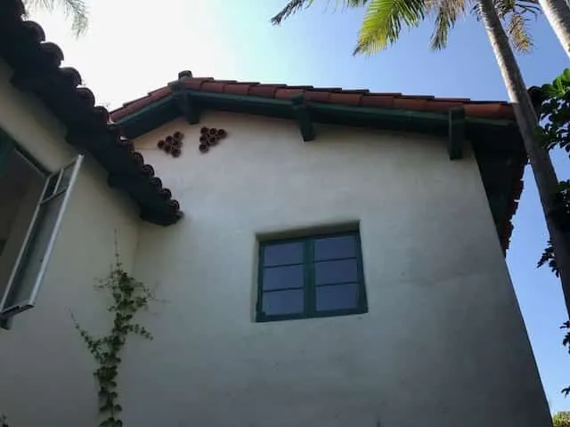 White stucco gable and green window trim after repainting