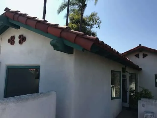 Spanish-style stucco home with green trim after painting