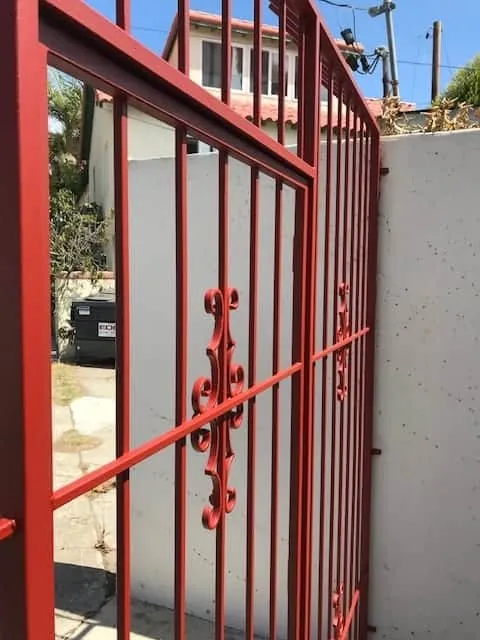 Red wrought iron gate repainted