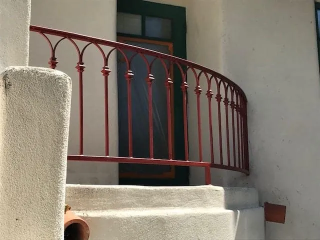 Red wrought iron railing repainted at the front steps
