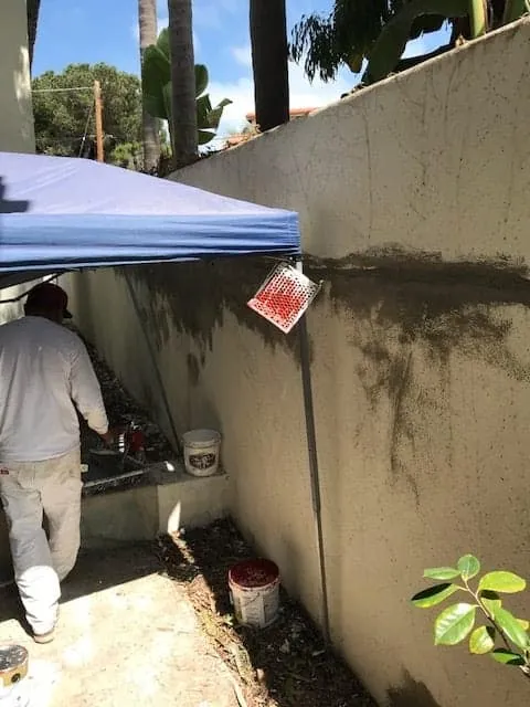 Fresh stucco patches along a side wall before painting