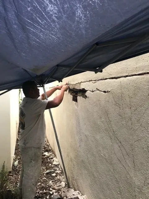 Crew member patching a long stucco crack