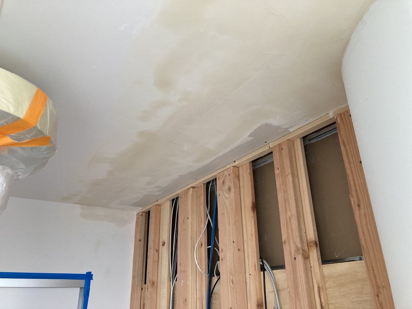 Ceiling with unfinished drywall and exposed wooden framing