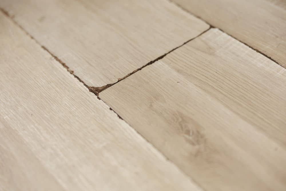 Close-up of light-colored wooden flooring with a visible seam