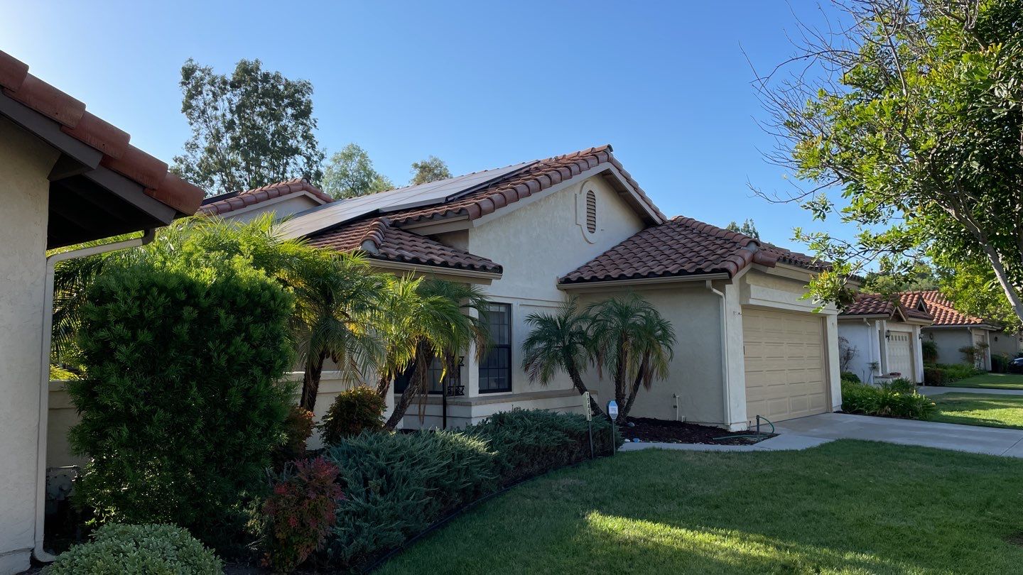 Front view of a house with a tile roof and landscaped yard