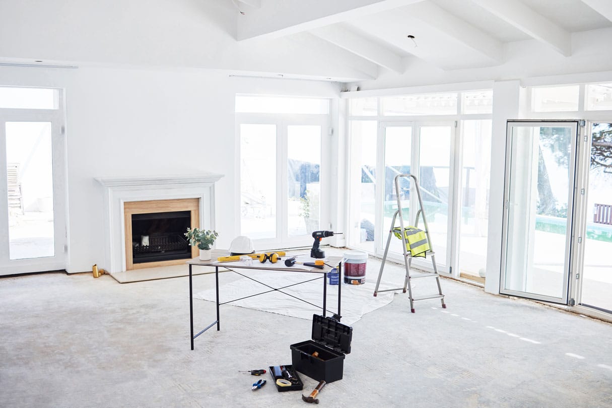 Interior painting in San Diego project with tools and supplies in a bright living room