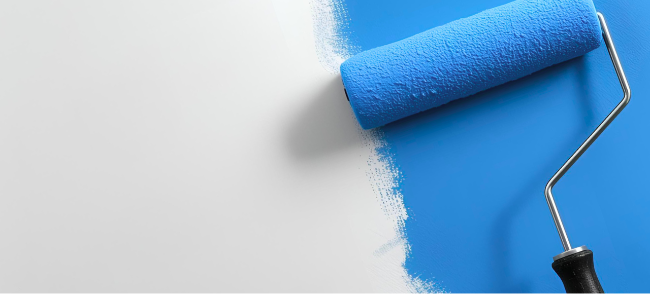 Paint Roller and White Wall Blue paint roller partially touching a white wall.